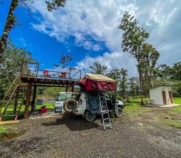 Zona de camping de Lumbres Arenal con plataforma y tienda sobre vehículo